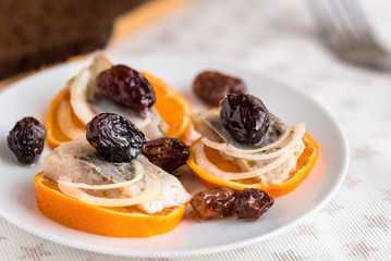 Appetizer food. Salted herring pieces with raisins, marjoram, onion and orange.