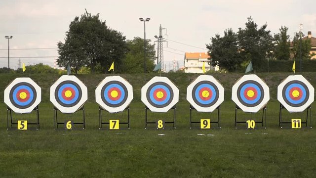 Several targets set in a wide green camp for an archery competition.