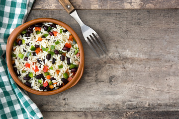 Traditional cuban rice, black beans and pepper on wooden table background. Moros y cristianos.