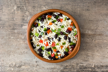 Traditional cuban rice, black beans and pepper on wooden table background. Moros y cristianos.