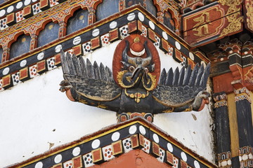 Wood carving of tibetan garuda and dragons on monastery façade in Bhutan