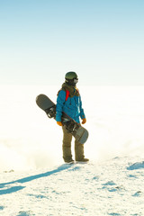 Fototapeta na wymiar Winter sports concept - snowboarder holding board in hands at the very top of a mountain - outdoors shot