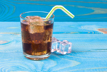 Sweet, fizzy drink with ice on a blue background.