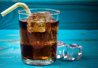 Sweet, fizzy drink with ice on a blue background.