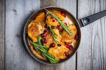 Roasted christmas chicken in a pan with cranberry and rosemary. Selective focus. Shallow depth of field.