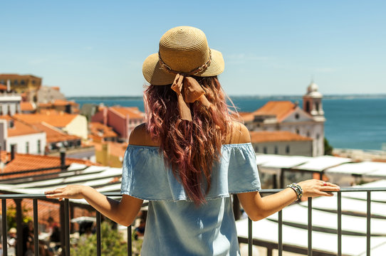 Young woman looking at Lisbon city panorama of Alfama on trip
