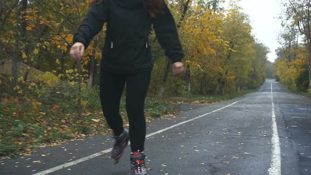 Young Woman On Roller Skates among beautiful autumn trees