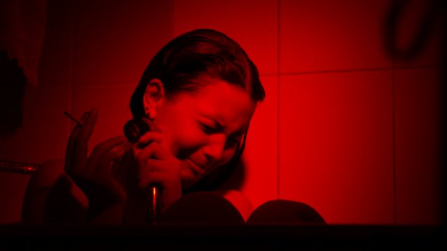 Crying young girl with cigarette in shower. Depression, vilolence, abuse concept.