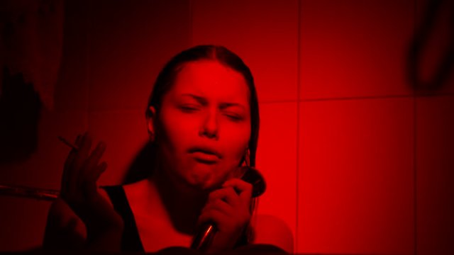 Crying young girl with cigarette in shower. Depression, vilolence, abuse concept.