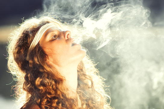 Beautiful free hippie girl blowing smoke - Vintage effect photo