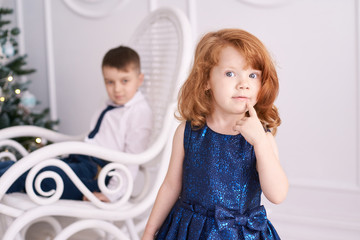 Little girl. Interest. Blue dress. Light background