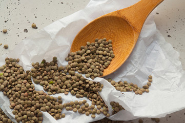 green lentil grains on a wooden spoon
