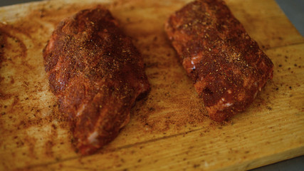 Closeup of meat ribs with spice on cutting board at restaurant kitchen