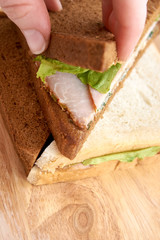 White and black bread. Sandwich with ham. Light background