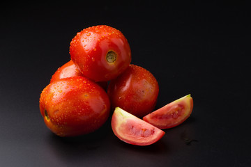 Fototapeta na wymiar Ripe red tomatoes isolated on black background