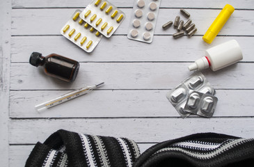 Pills medicine & capsule pills medicine & antibiotics, thermometer on white wooden table. Top view of doctor workplace. Flat lay border composition.