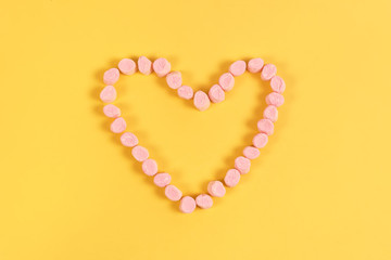 marshmallow sweets placed in heart shape.valentine's day and love concept on yellow background