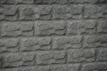The texture of a stone fence with rectangular blocks and concrete seams.