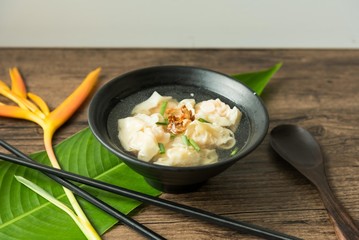 Shrimp wonton with braised pork in soup on wooden table - Asian food style  / Select focus image