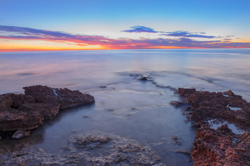 The calm sea in a very cloudy sunset