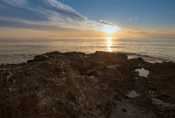 The calm sea in a very cloudy sunset