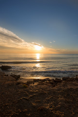 The calm sea in a very cloudy sunset