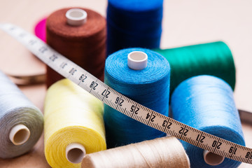 Pile of colorful spools of thread and measuring meter 