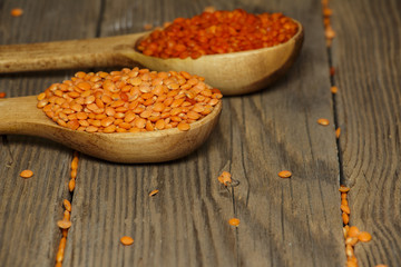 Lentils and spoon in a wooden bowl on an old table.
