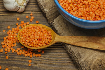 Lentils and spoon in a wooden bowl on an old table.