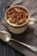 Coffee in a small Cup with marshmallows . Hot drink in dark colours in a welcoming environment. Selective focus