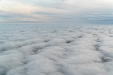 View from an airplane above the clouds during blue hour