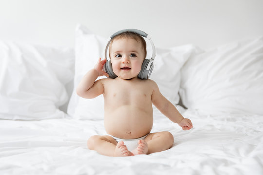 happy baby listening to music with headphones