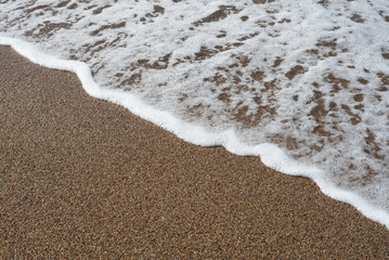 Foam wave of the sea on the sandy beach