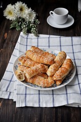 On a wooden table on a platter fresh bananas baked in a dough