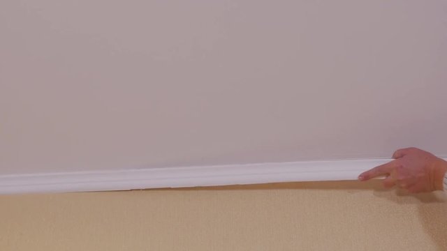 Worker breaks old baseboard