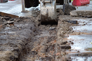 excavator removes road asphalt