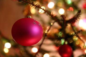 Fototapeta na wymiar Christmas tree ball bathed in the glow of Christmas lights. 