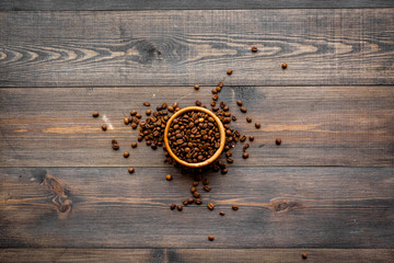 Coffee background. Roasted beans in bowl on dark wooden background top view copyspace