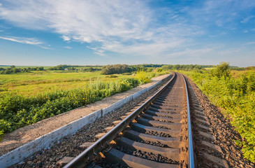 Fototapeta premium Railway station against beautiful sky at sunset. Industrial landscape with railroad, colorful cloudy blue sky.