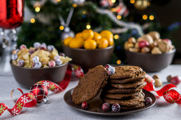 Fototapeta na wymiar freshly baked chocolate chip cookies on a table with blurred christmas tree background.