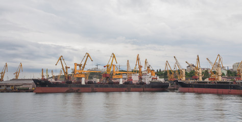 Fototapeta na wymiar Lifting cargo cranes, ships and grain dryer in Sea Port of Odessa, Black Sea, Ukraine.