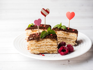Dessert Tiramisu with mint and fresh raspberries on white wooden table. Red hearts Valentine's Day