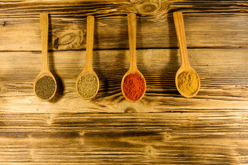 Spoons with the different spices on wooden table. Top view