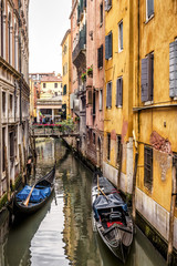 Fototapeta na wymiar Old narrow street with gondolas in Venice