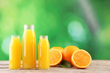 Fototapeta na wymiar Bottles of orange juice on wooden table