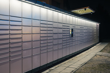 Automated parcel terminal (parcel locker, post terminal) on the street by night, Europe.