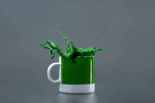 Green liquid splashing out of a green mug