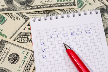 Checklist on a notepad with money and pen