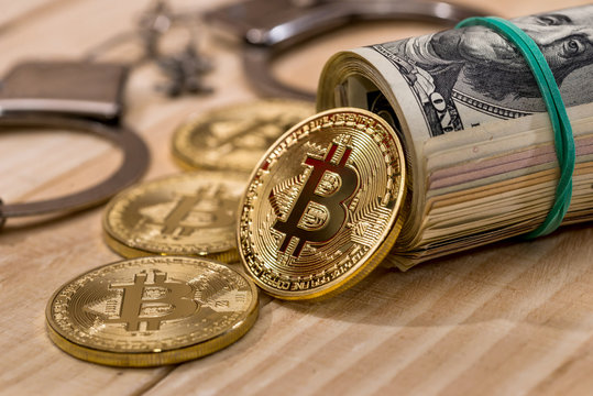handcuff with dollar and bitcoin. close up