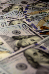 Close up of dollars. American dollars are scattered in the frame. The face of dollars. different parts of the frame are blurred. Green money with blue ribbon.